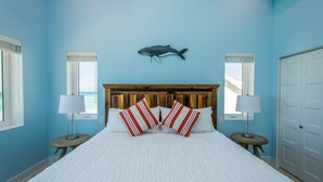 A bedroom with a wooden headboard, white bedding, and striped pillows. - LUXURY PENTHOUSE!! Courtesy SUV Included, PaddleBoards, Bikes, Chairs & More! (Cockburn Town)