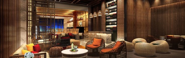 A modern lounge area with wicker furniture, a bar, and a bookshelf.