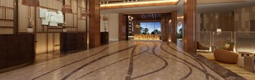 Un vestíbulo amplio con mostrador de recepción, zona de estar y vistas al exterior.