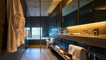 A modern bathroom with a glass shower enclosure, a wooden vanity, and a large mirror.