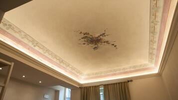 A room with a high ceiling, decorative moldings, and a chandelier.