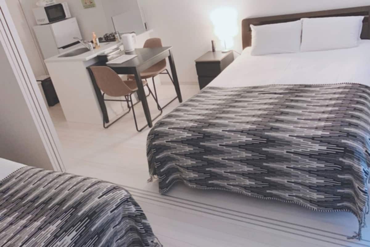 A hotel room with a bed, a desk, and a chair.