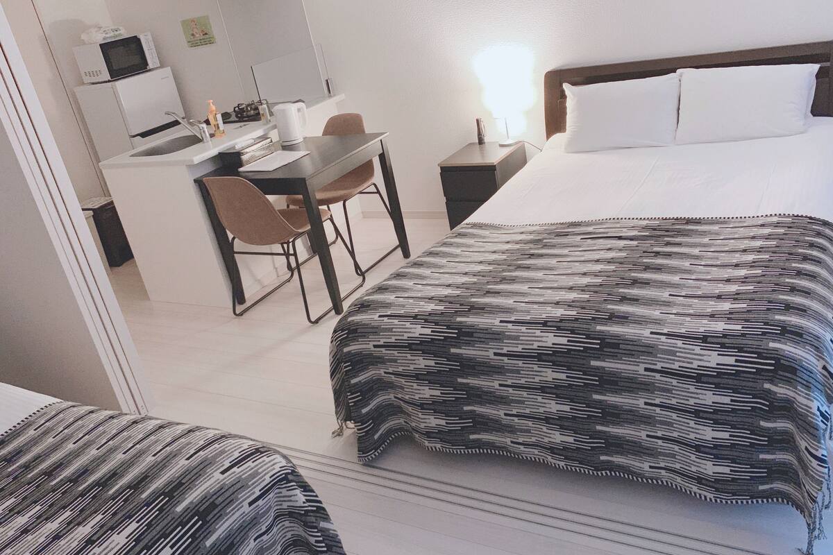 Una habitación de hotel con una cama, un escritorio y una silla.