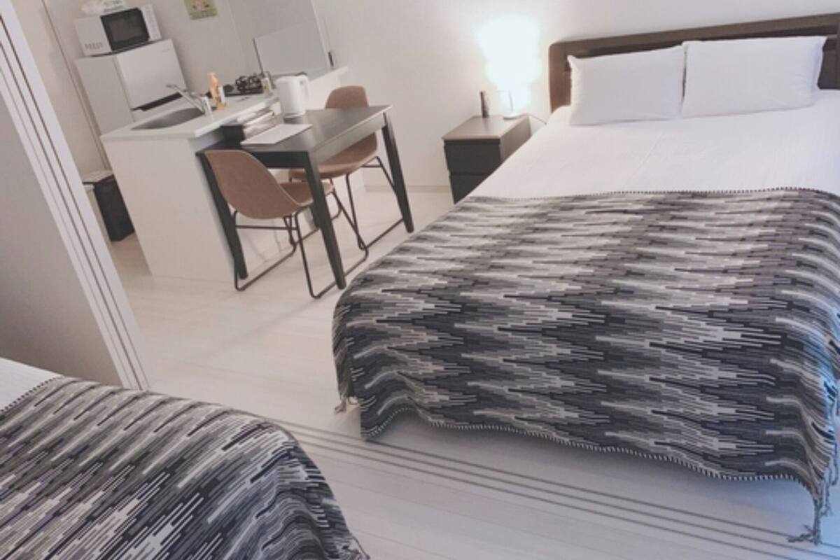 A hotel room with a bed, a desk, and a chair.