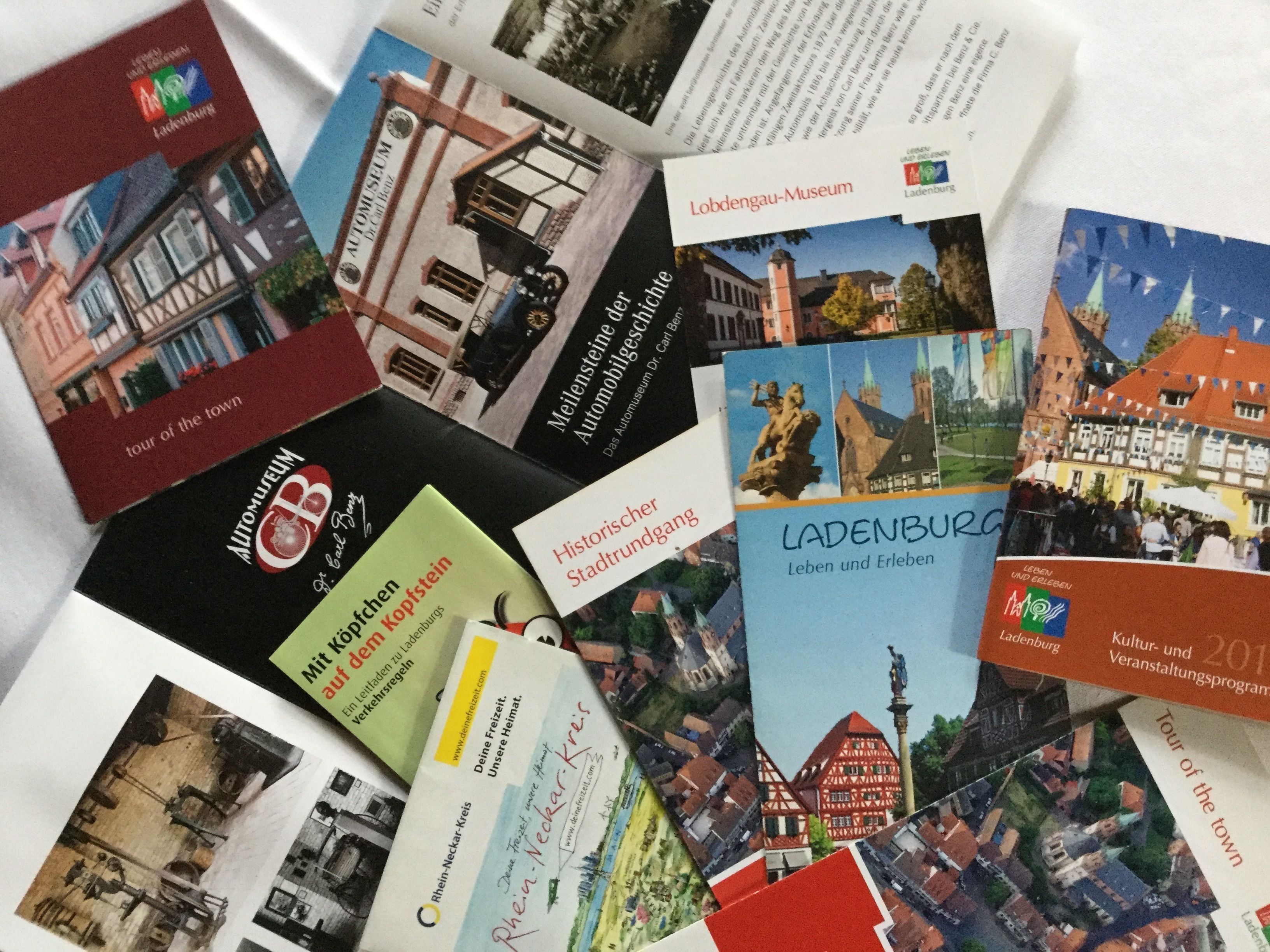 Una selecció de fulletons i tríptics amb diverses imatges d'edificis i monuments, probablement relacionats amb una ciutat o poble.