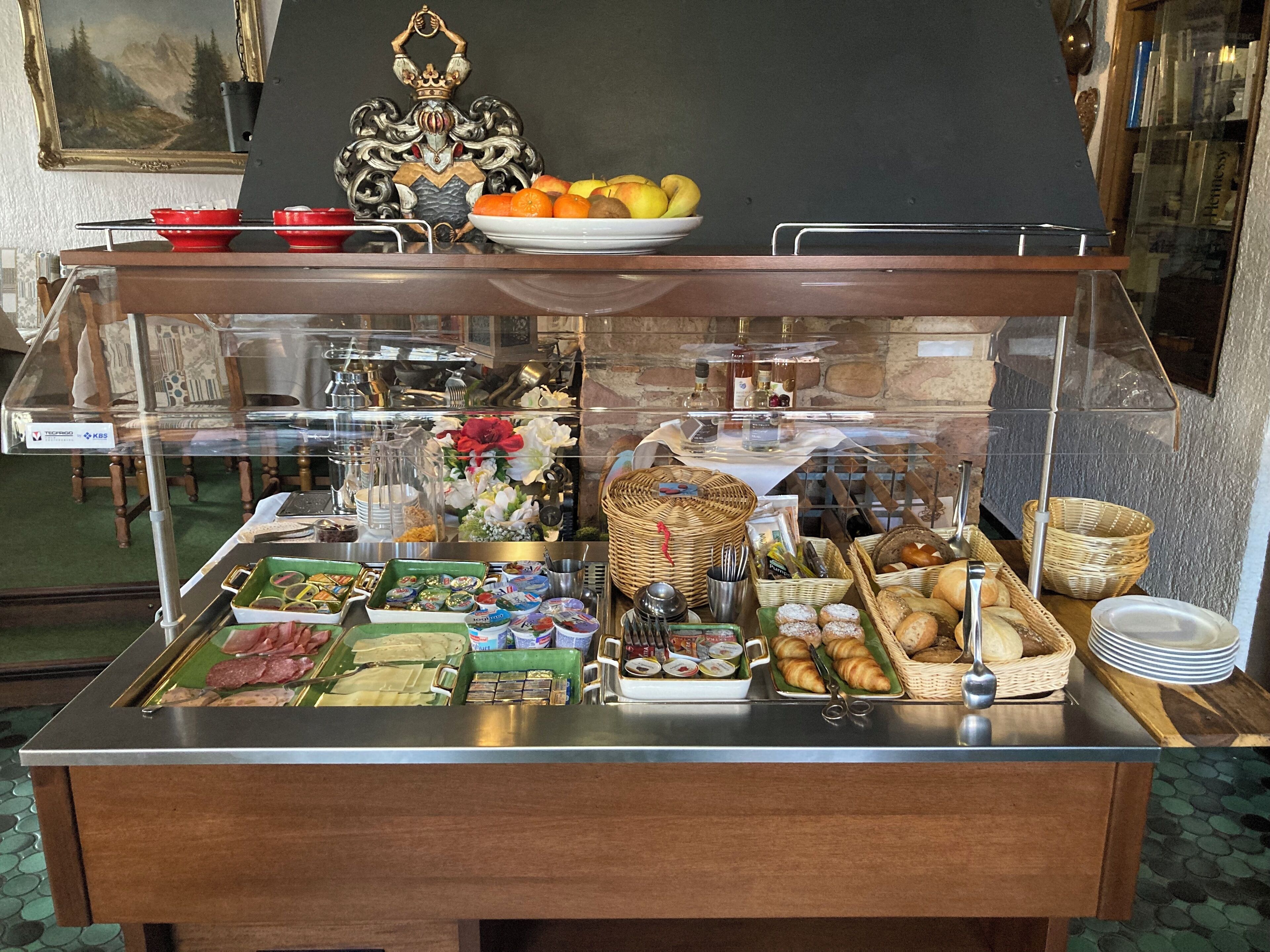 Ein reichhaltiges Buffet mit verschiedenen Speisen, darunter Früchte, Gebäck und Beilagen.