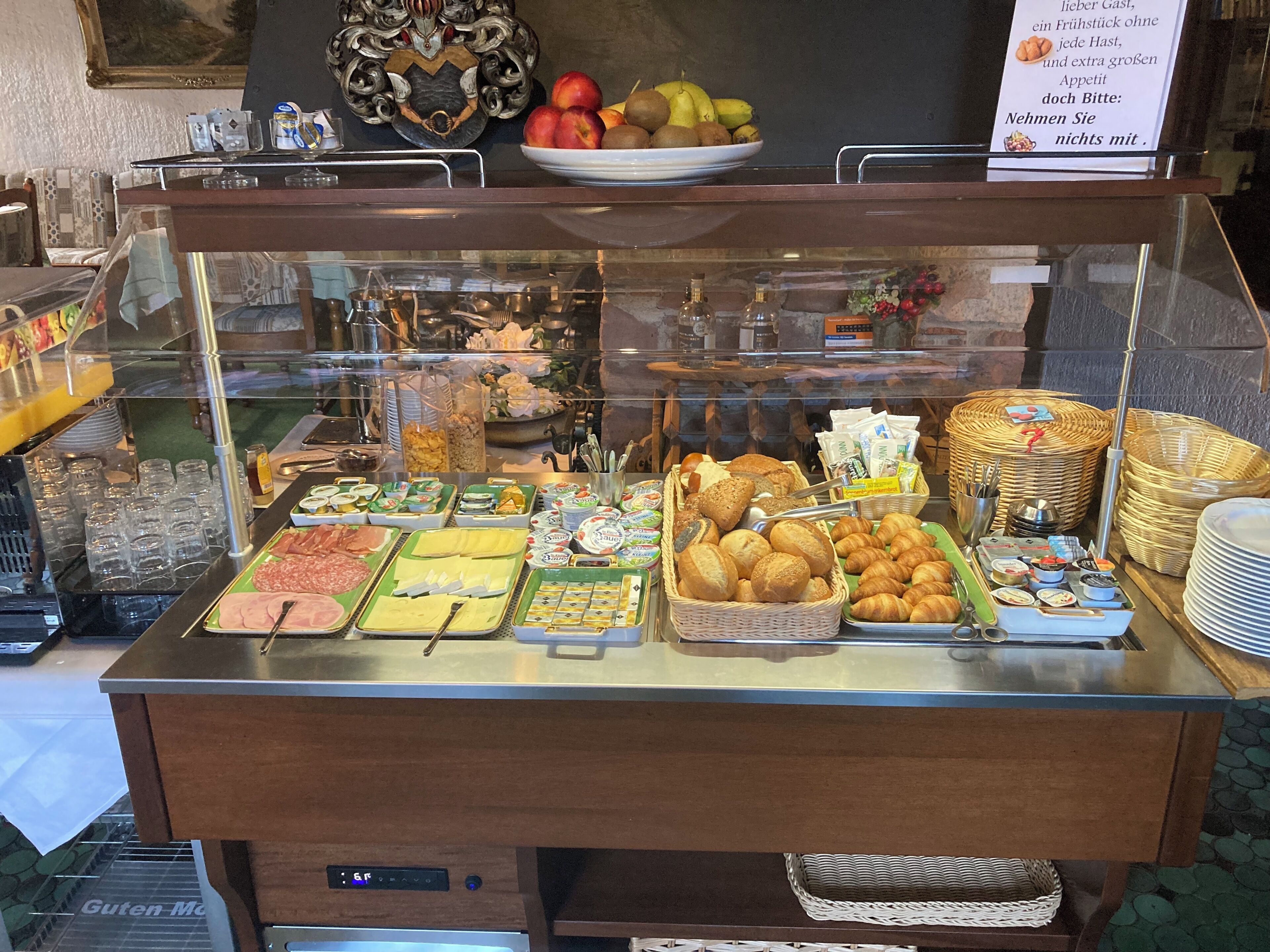 Un bufé con diversas opciones de comida y un cartel arriba.