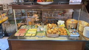 Un bufé con diversas opciones de comida y un cartel arriba.