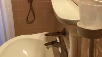 A bathroom with a bathtub, a sink, and a shower.