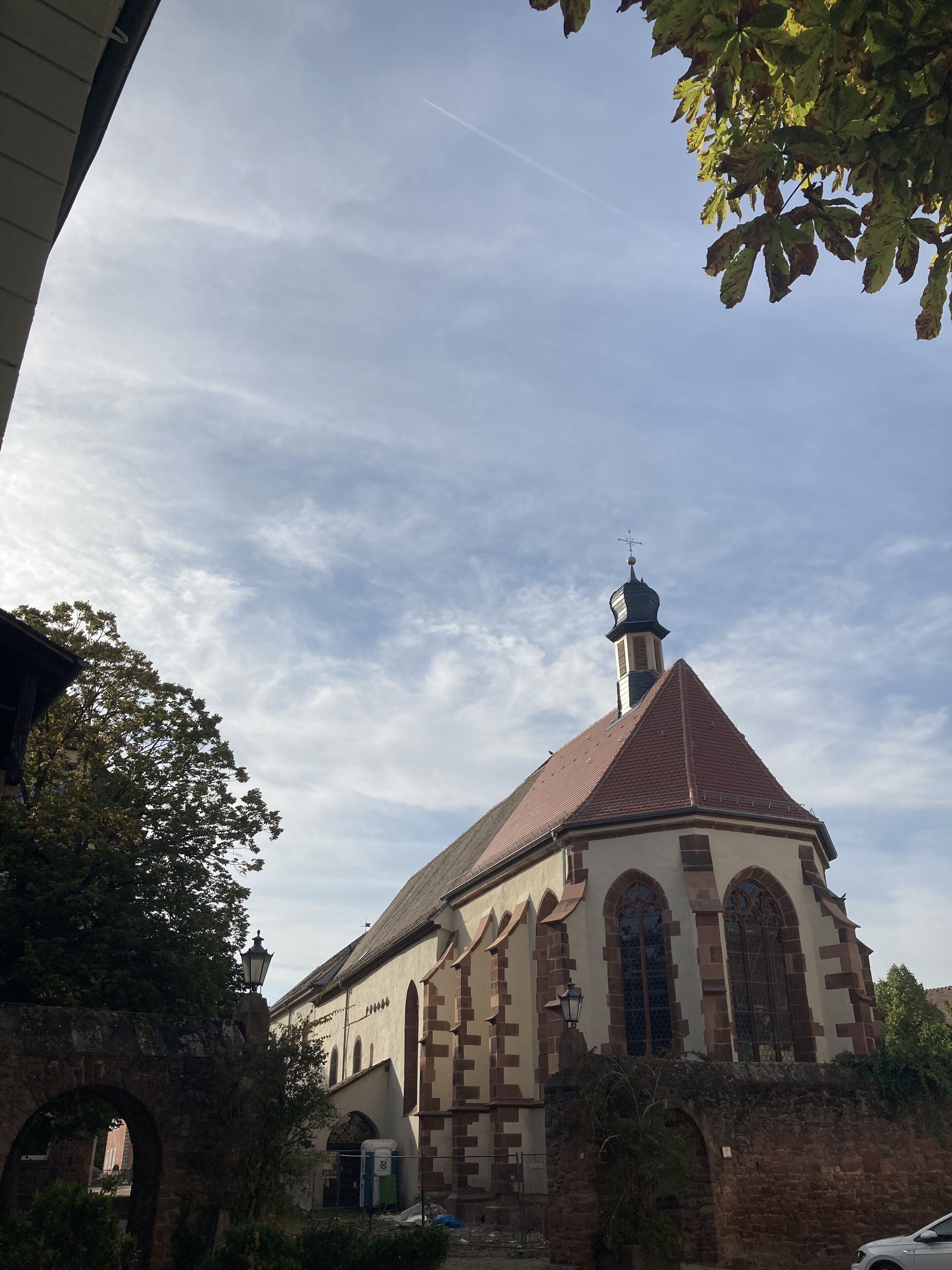 A church with a prominent steeple, arched windows, and a brick facade.