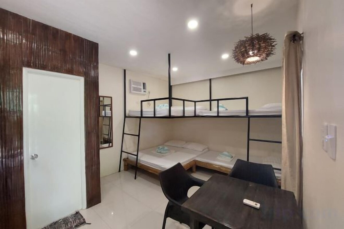 A room with bunk beds, a table, and a chair.