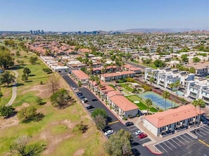 Una zona residencial con edificios de varios pisos, un estacionamiento y una cancha deportiva.