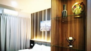 Habitación de hotel con cama, pared de madera con estantes, un globo terráqueo y una vela.