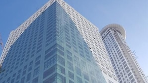Un edificio de gran altura con fachada de vidrio moderna y un diseño estructural blanco característico.
