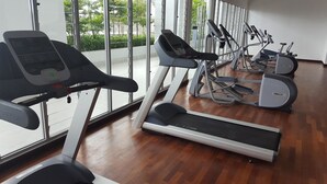 Un gimnasio con cintas de correr, elípticas y bicicletas estáticas.