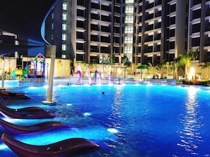 A swimming pool with multiple lanes, a water fountain, and a children's play area.