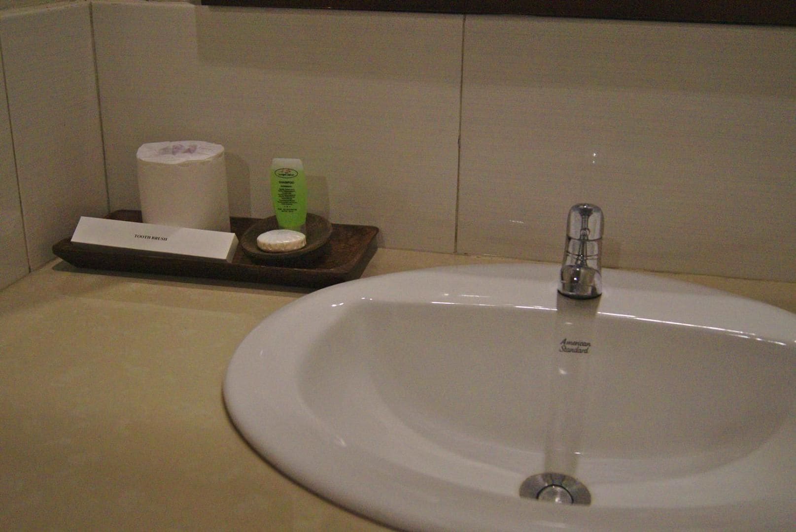 Un lavabo de salle de bain avec un robinet, un porte-brosse à dents avec une brosse à dents et un distributeur de savon.