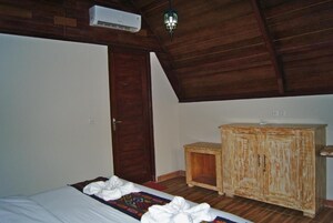 Una habitación con una cama, un armario de madera, una puerta y un ventilador de techo.