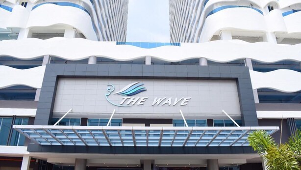 Un bâtiment moderne au design ondulant, sur lequel on peut lire l’inscription « THE WAVE ».