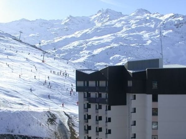 A modern hotel with a ski slope in the background.