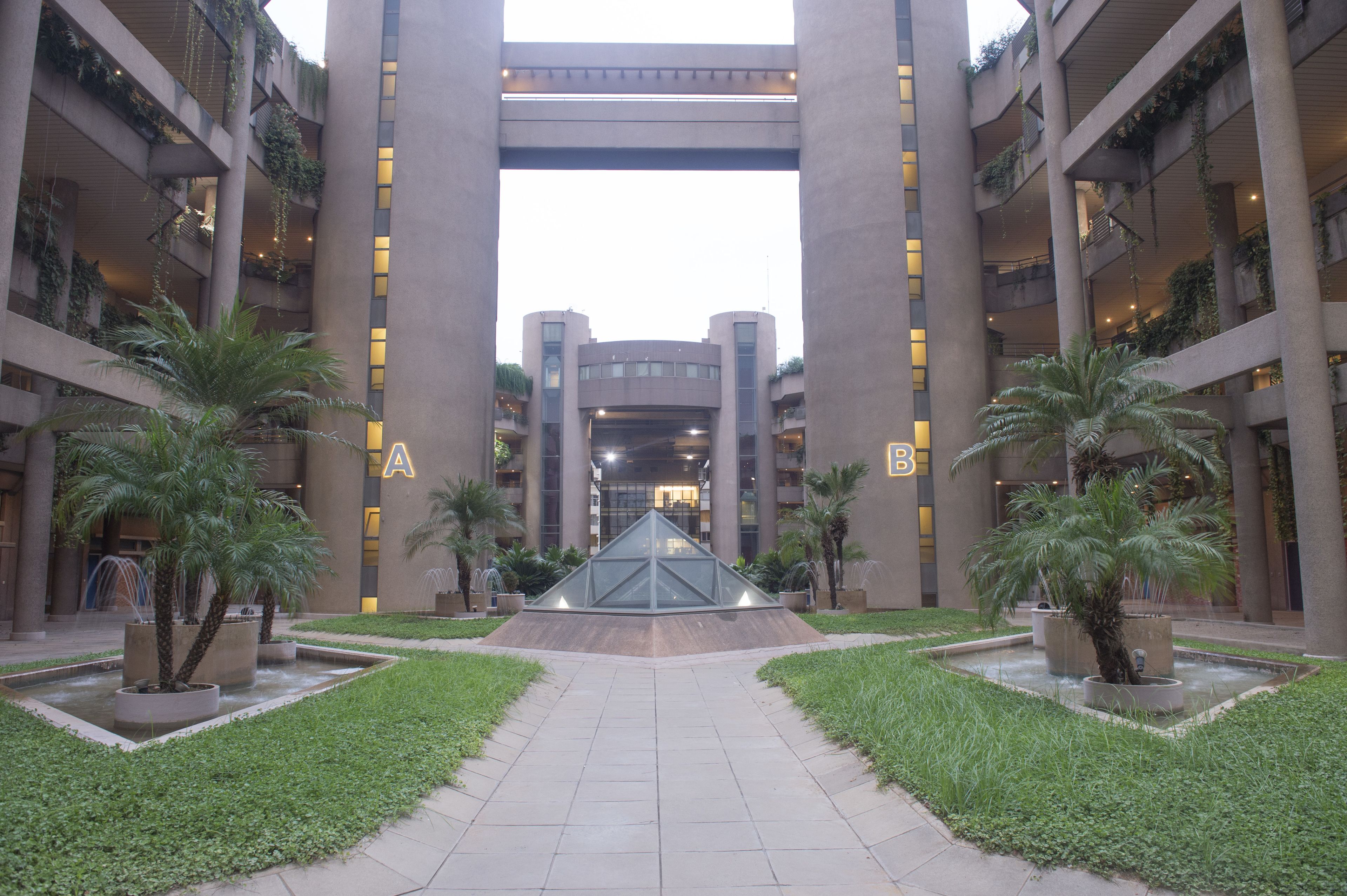 A building with a central atrium, multiple floors, and a geometric glass structure in the middle.