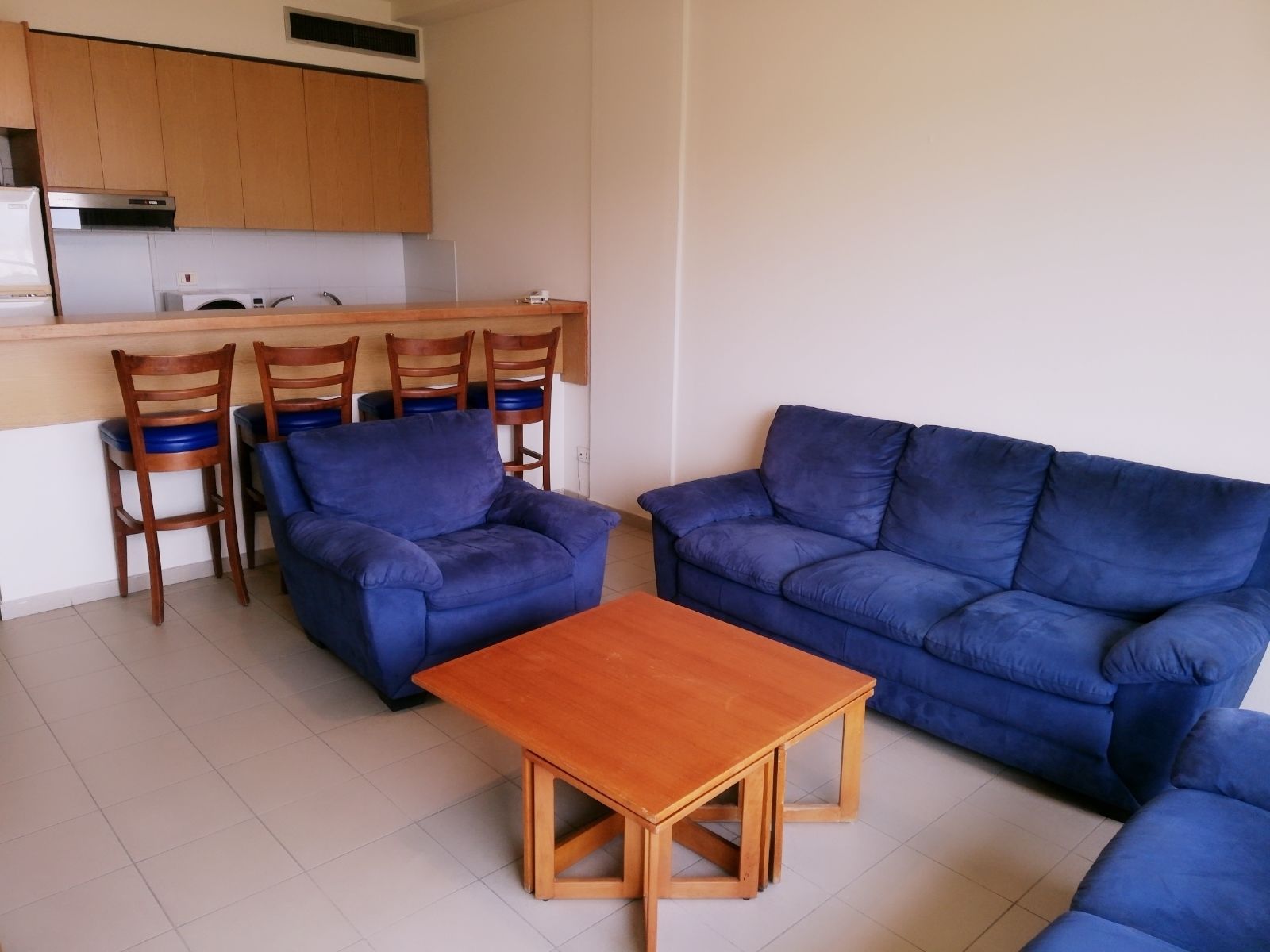 Ein gemütlicher Wohnbereich mit Sofa, Couchtisch und Essbereich mit Stühlen.
