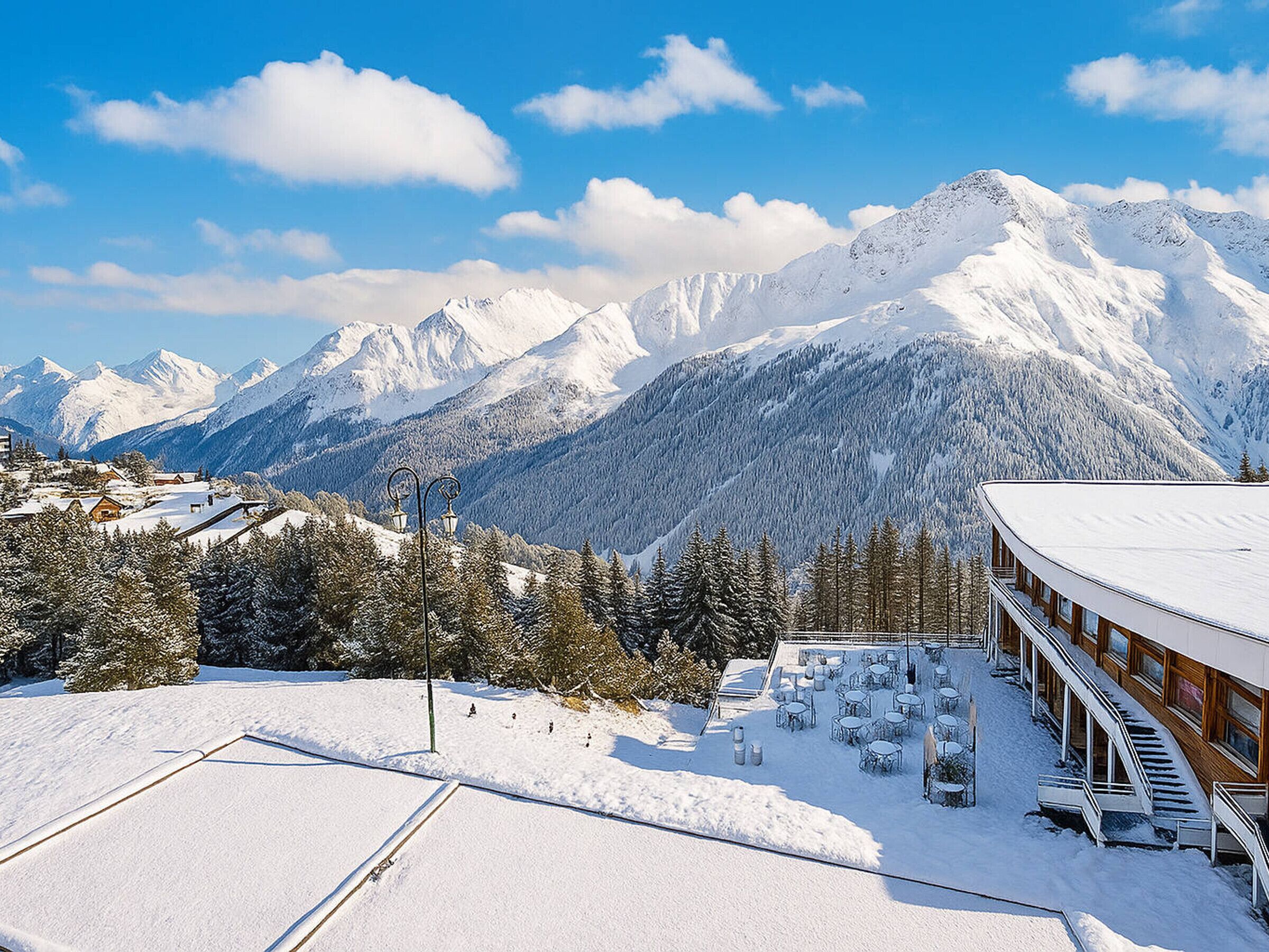 A snow-covered mountain landscape with a building featuring outdoor seating and a ski lift.