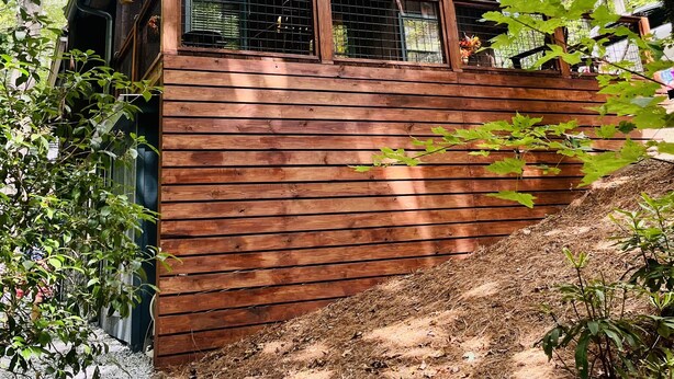 Un rustico chalet con tetto spiovente, pareti in legno e un piccolo balcone con ringhiera in metallo.