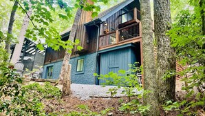 Una baita rustica con facciata in legno, diverse finestre e un balcone.