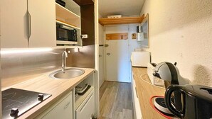 A compact kitchen with a sink, microwave, and toaster. - Economical studio for 4 with south-facing balcony in Les Menuires, pets allowed (Les Menuires)