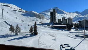 A snow-covered ski resort with ski lifts, buildings, and a mountain backdrop. - Economical studio for 4 with south-facing balcony in Les Menuires, pets allowed (Les Menuires)