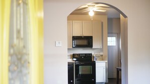 A kitchen with white cabinets, a black microwave, and a stove. - Quiet, Convenient Location w/ Great Amenities-Full Kitchen-Washer/Dryer-5g Wifi  (Hyrum)