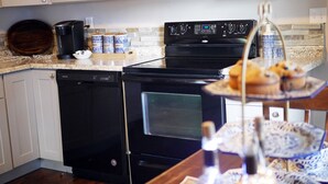 A kitchen with a dishwasher, stove, microwave, and a coffee maker. There are tea and sugar containers on the counter. - Quiet, Convenient Location w/ Great Amenities-Full Kitchen-Washer/Dryer-5g Wifi  (Hyrum)