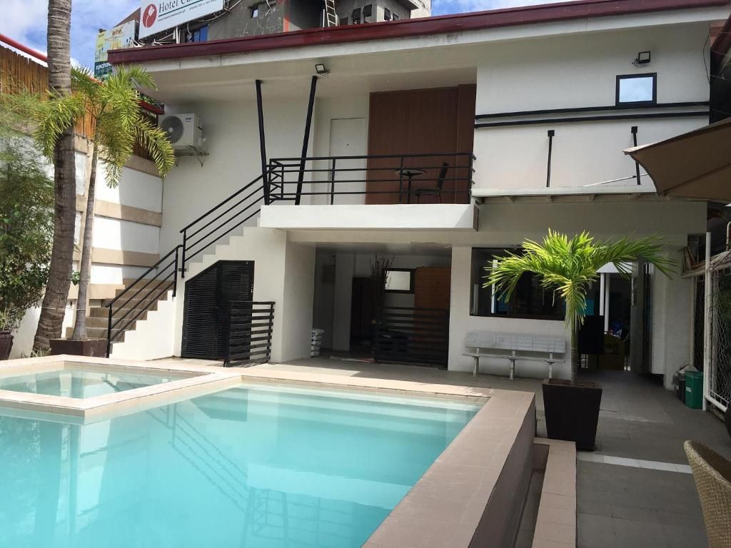 Un hôtel doté d’une piscine, d’un espace extérieur aménagé et d’un escalier menant à un balcon.