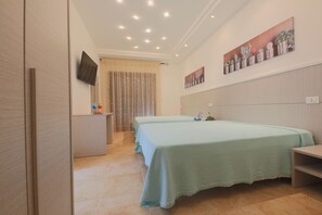 Deluxe vierpersoonskamer, op tussenverdieping | Luxe beddengoed, een minibar, een kluis op de kamer, een bureau