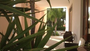 Une pièce avec vue sur un jardin, une chaise et une table.