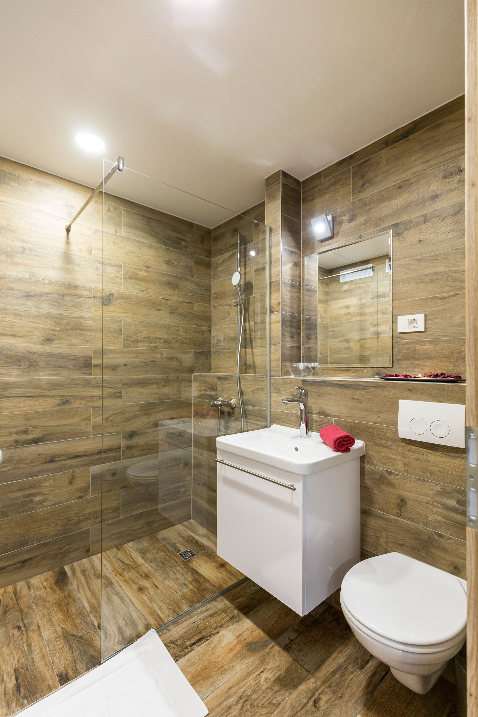 Une salle de bain moderne avec une douche à parois de verre, un lavabo blanc et des toilettes.