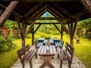 An outdoor wooden pavilion with picnic tables and benches, surrounded by greenery. - Willa tuŻur (Osie)