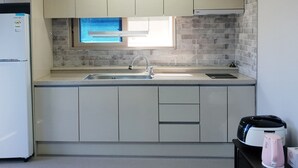Eine moderne Küche mit integriertem Kühlschrank, Spüle und einem Fenster über der Arbeitsfläche.