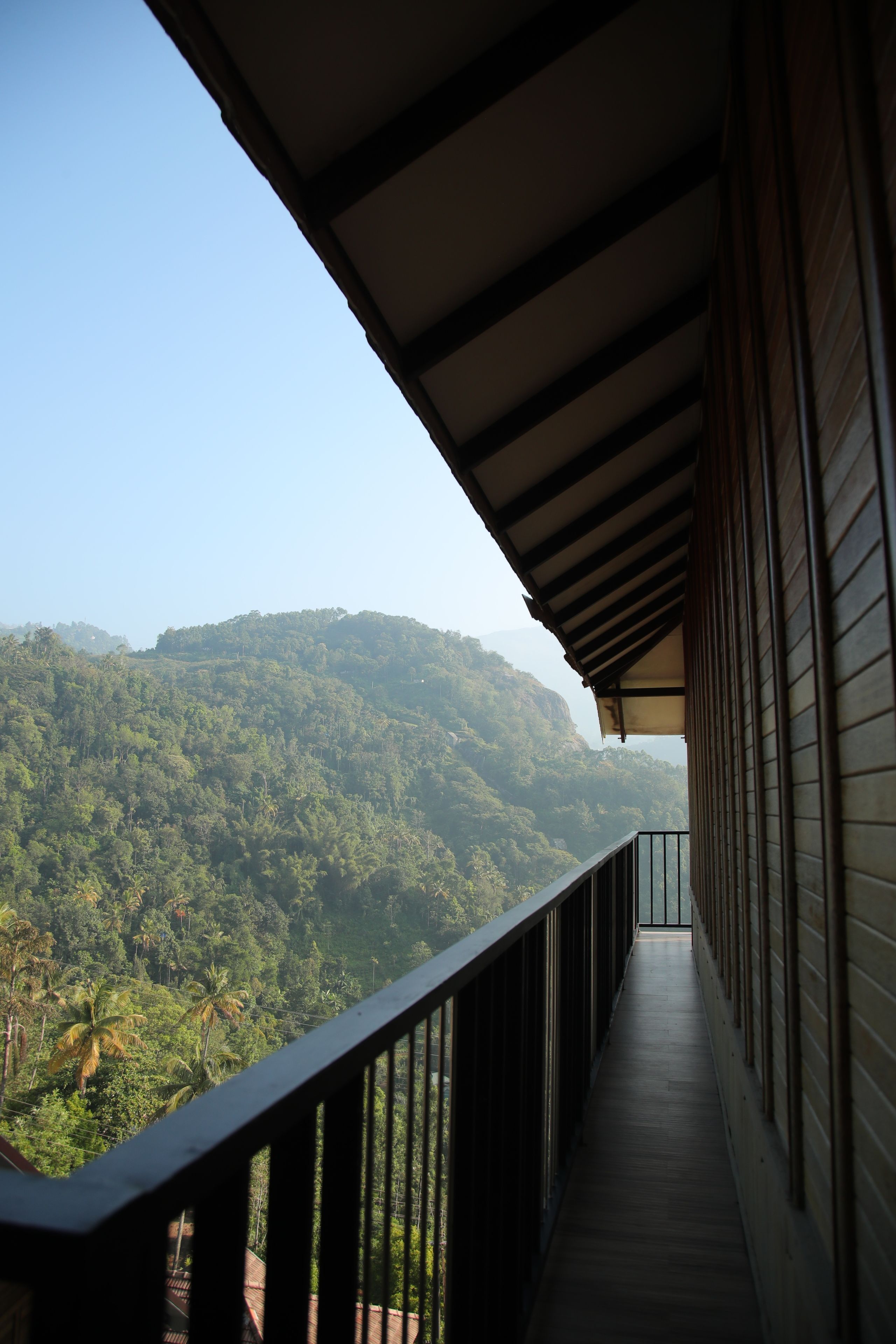 A balcony with a view of a forested hillside.