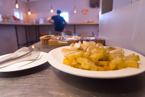 A dining table with a plate of sliced fruit and a plate of sliced almonds. - V Hotel (Taipei)