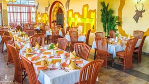 Un restaurante con varias mesas y sillas, decorado con manteles y servilletas.