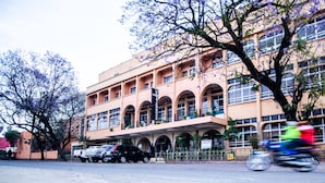 Un edificio de varios pisos con un patio central, ventanas grandes y un letrero que indica un hotel.
