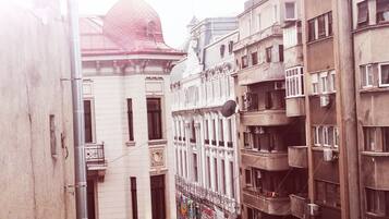 Una calle estrecha flanqueada por edificios con una cúpula destacada y balcones.