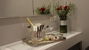 A tray with a champagne bottle, glasses, and chocolates on a white counter. - Millina Suites In Navona (Rome)