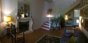 A living room with a fireplace, a staircase, and a sofa.