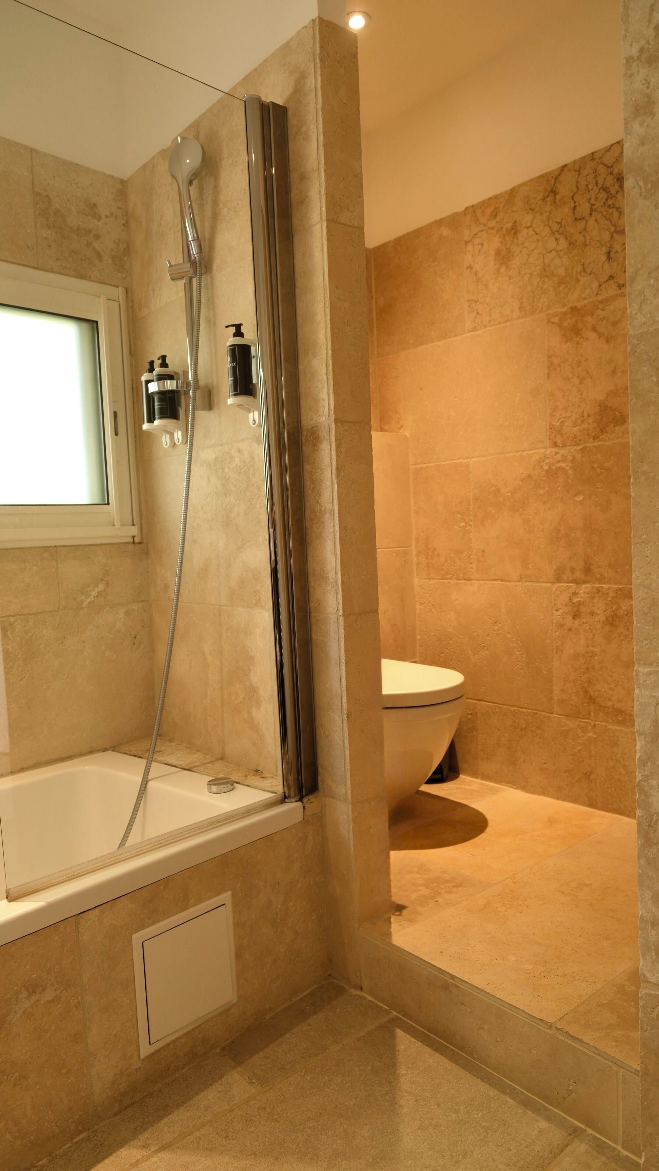 Une salle de bain moderne équipée d’une baignoire, d’un espace de douche et de toilettes.