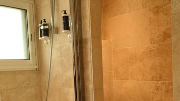 Une salle de bain moderne équipée d’une baignoire, d’un espace de douche et de toilettes.