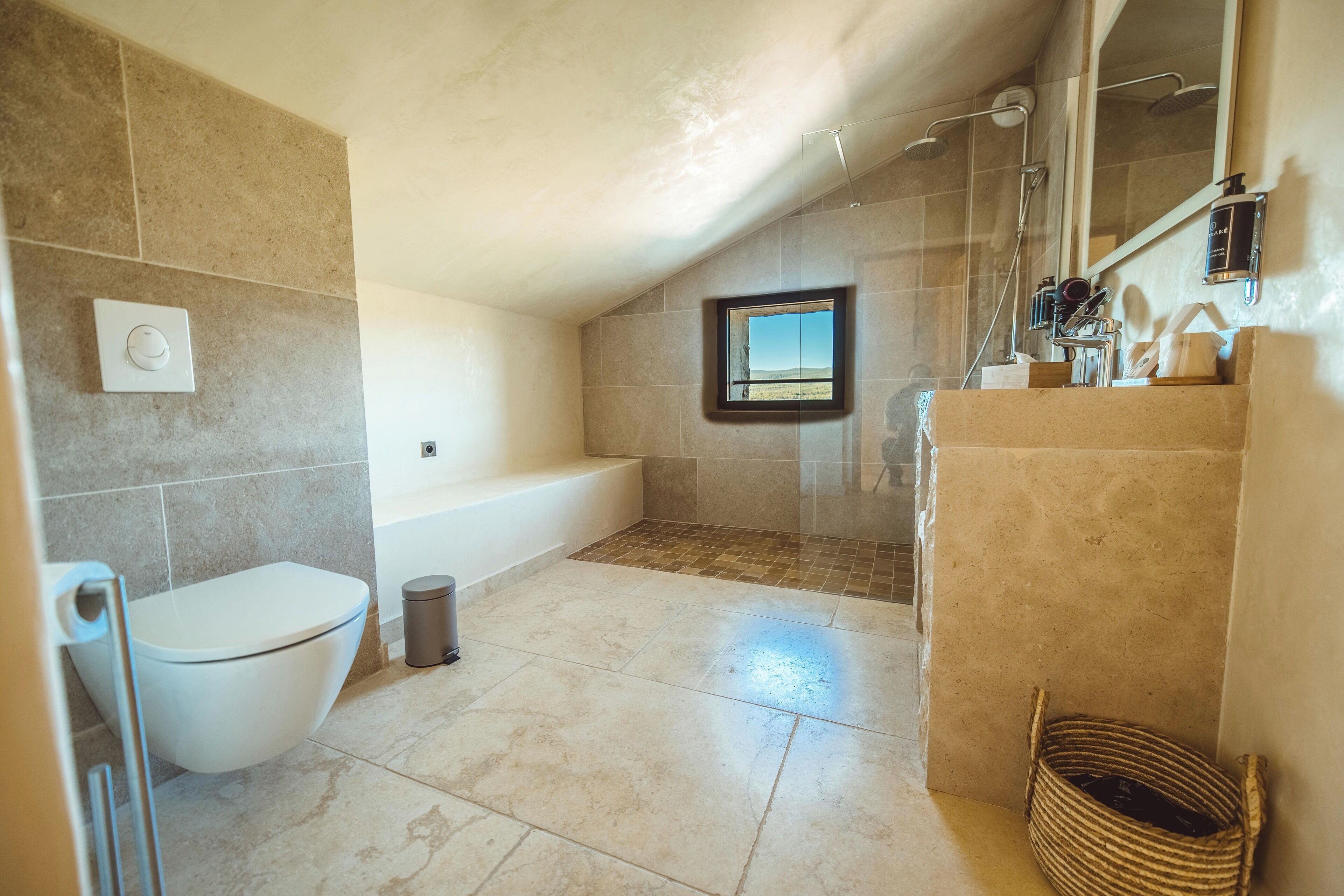 Een badkamer met een bad, toilet en douche.