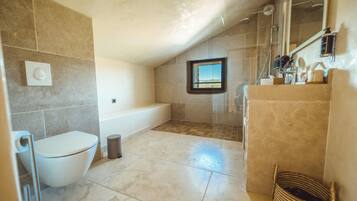 Een badkamer met een bad, toilet en douche.